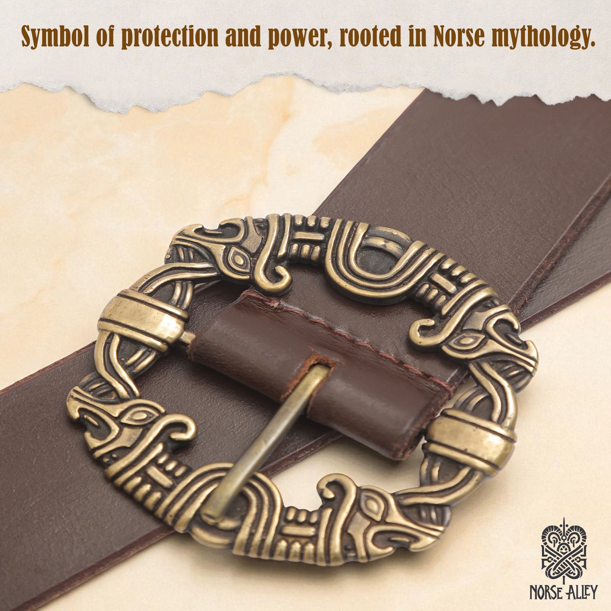 A close-up of the Norse Alley The Drakkar Belt—a Viking leather belt with a gold-colored, Norse-inspired buckle. Text: “Symbol of protection and power, rooted in Norse mythology.” Norse Alley logo appears in the corner.