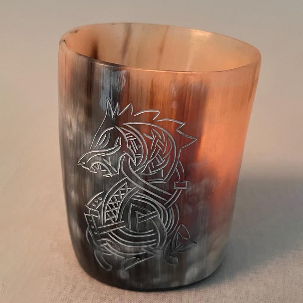 The Norse Alley Viking Drinking Horn Shot Glass features a carved Norse wolf design with black, brown, and cream marbling. This handcrafted cup stands upright on a flat surface against a neutral background.
