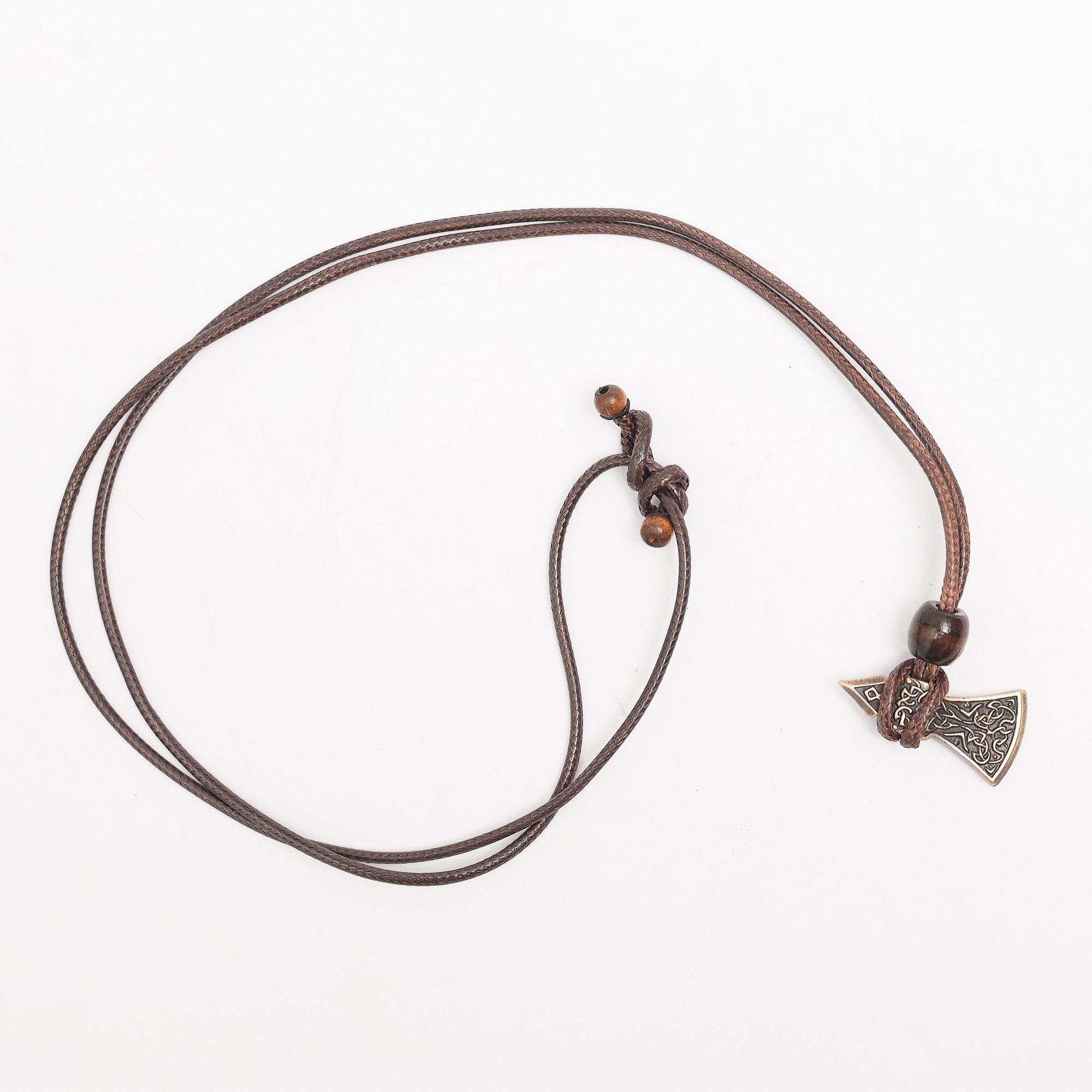 The Viking Axe Brass Pendant is a brown cord necklace with two wooden beads and a detailed, engraved axe pendant, showcased on a white background.