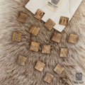 Handcrafted wooden tiles from the Younger Futhark Rune Set – 16 Handcrafted Tiles are laid out on a soft surface. A fabric pouch featuring the Norse Alley logo and “Made in India” is partially visible in the corner.