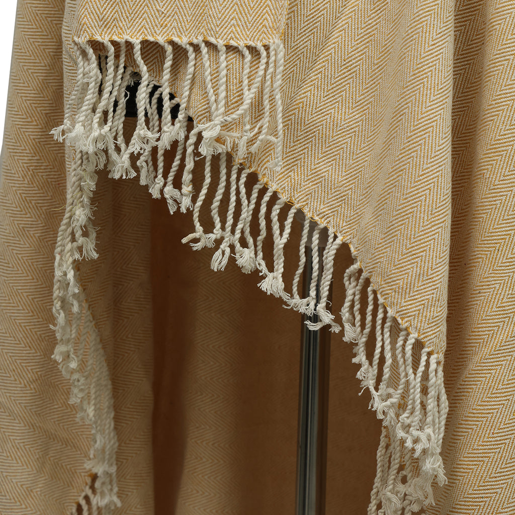 A close-up of the beige and yellow herringbone fabric with white tasseled fringe, highlighting the craftsmanship of Odin's Viking Cape- Unisex.