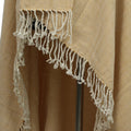 A close-up of the beige and yellow herringbone fabric with white tasseled fringe, highlighting the craftsmanship of Odin's Viking Cape- Unisex.