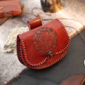 The Vegvisir leather Viking bag features reddish-brown leather, braided stitching, and an embossed Vegvisir symbol inspired by Norse mythology. Resting on fur and leather, it makes a unique gift for any Norse mythology enthusiast.