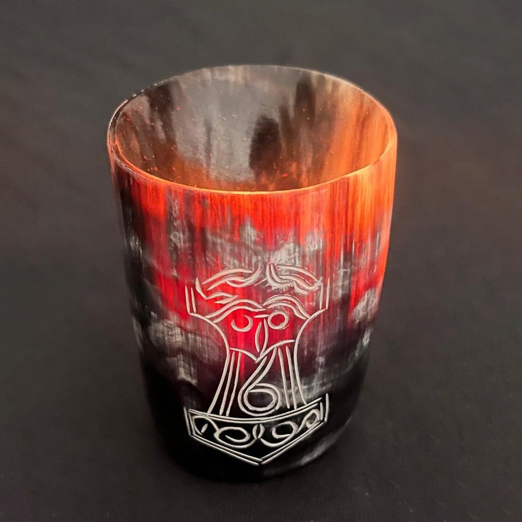 The Norse Alley Viking Drinking Horn Shot Glass features black, red, and orange streaks with an engraved Norse symbol—ideal as unique home decor or a standout piece in your drinking cup collection. Set against a dark background.