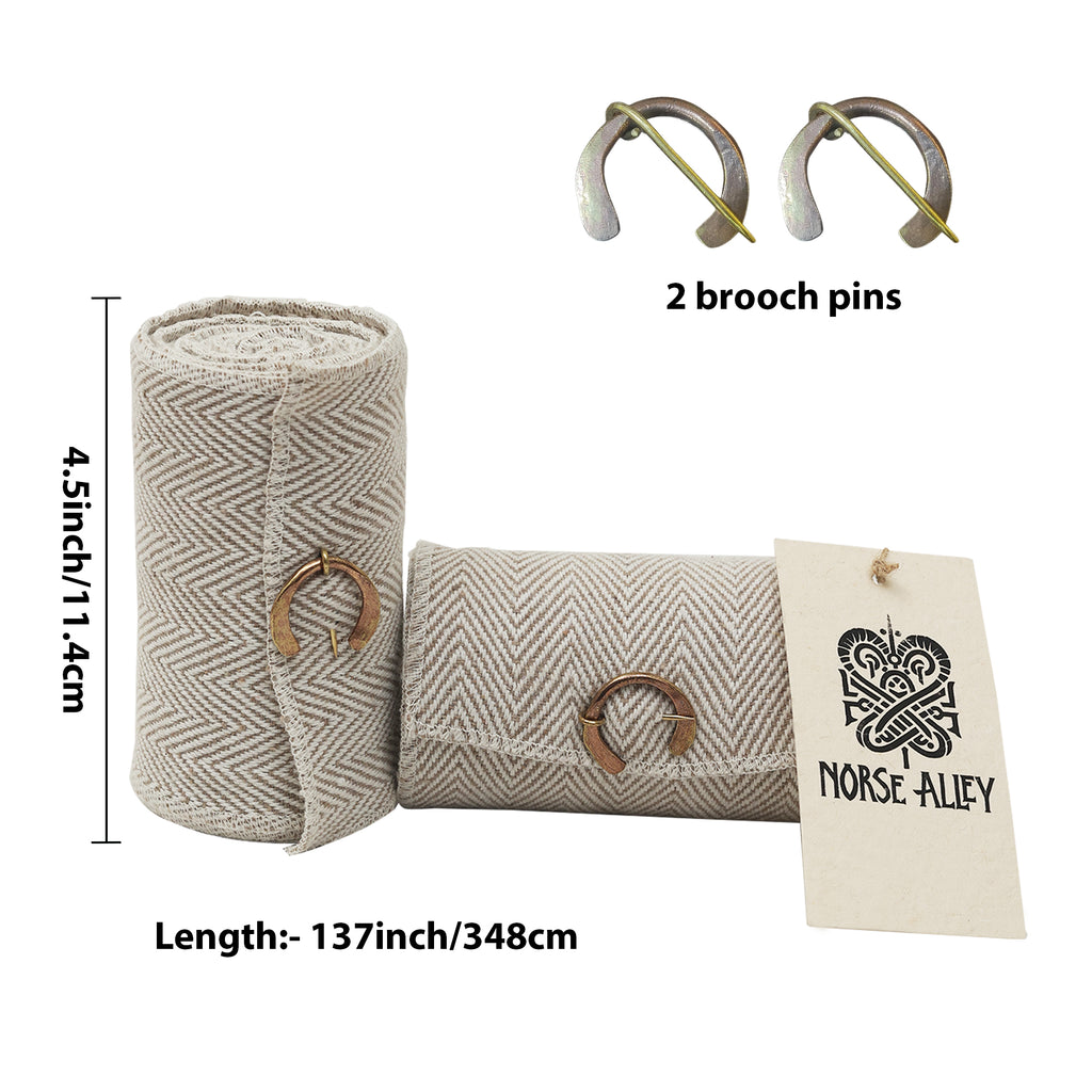 The Herringbone Viking Leg Wraps (Winingas) feature two beige herringbone-fabric strips, each with a bronze brooch pin. One is rolled; one folded with a Norse Alley tag. Includes 2 extra pins. Each strip: 4.5" high, 137" long.