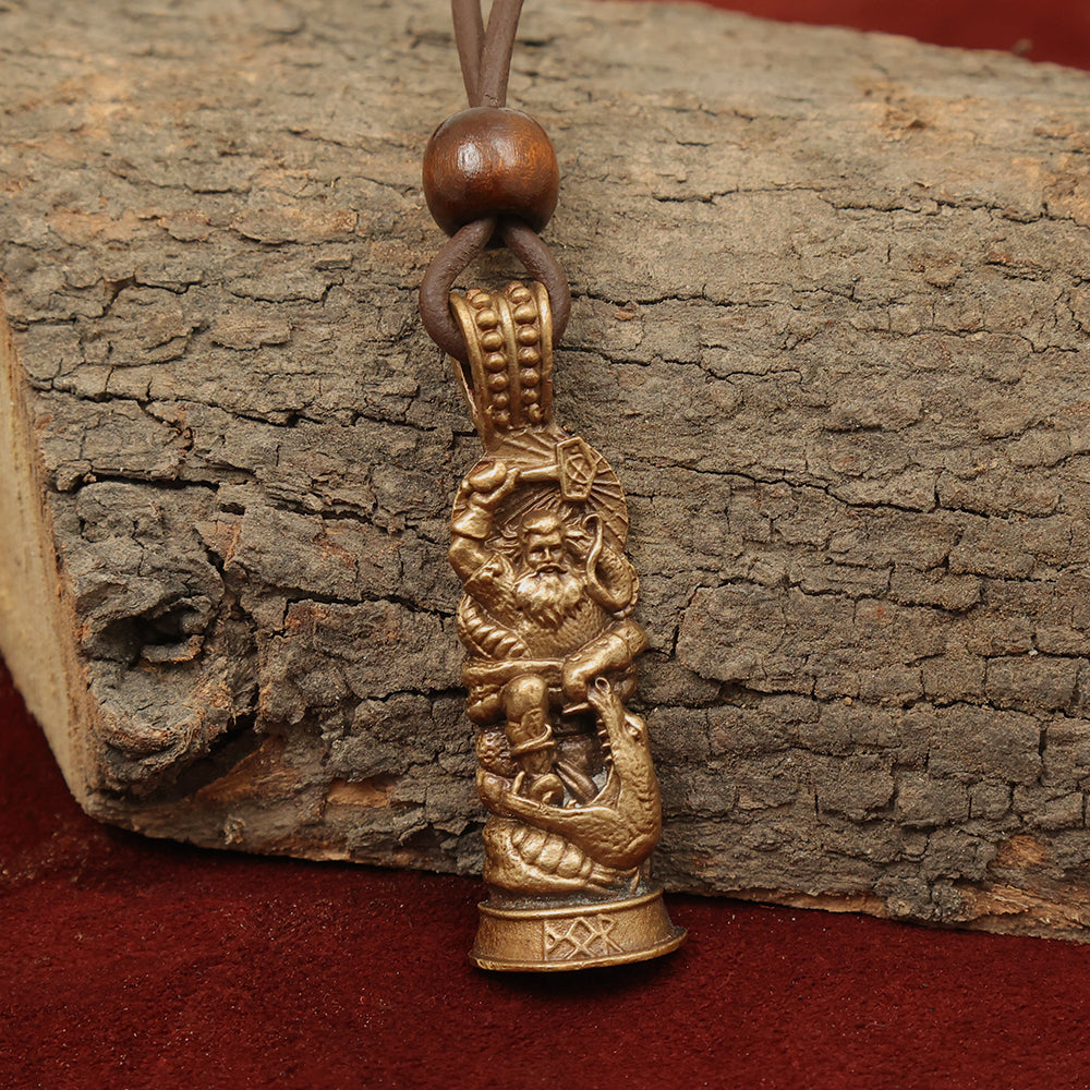 The Thor Warrior Pendant – Protector of Midgard features a detailed bronze Thor figure with sea motifs on a leather cord with wooden beads, displayed against tree bark and reddish-brown fabric—a striking addition to Norse gods jewelry.