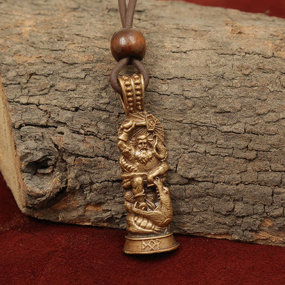 The Thor Warrior Pendant – Protector of Midgard features a detailed bronze Thor figure with sea motifs on a leather cord with wooden beads, displayed against tree bark and reddish-brown fabric—a striking addition to Norse gods jewelry.