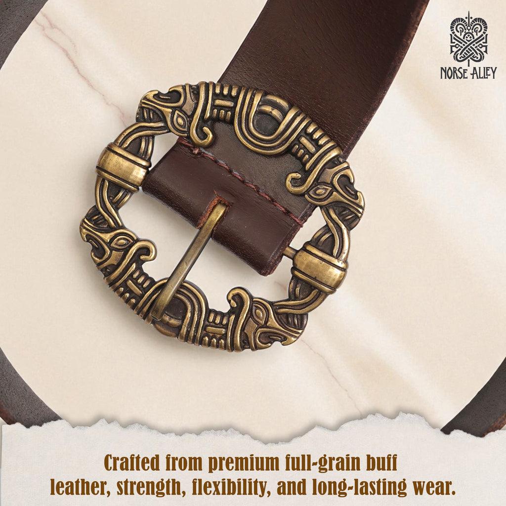 A close-up of the Norse Alley The Drakkar Belt: brown full-grain buff leather with an ornate, antique gold buckle featuring intricate Norse designs. Text: Crafted for lasting strength, flexibility, and authenticity.
